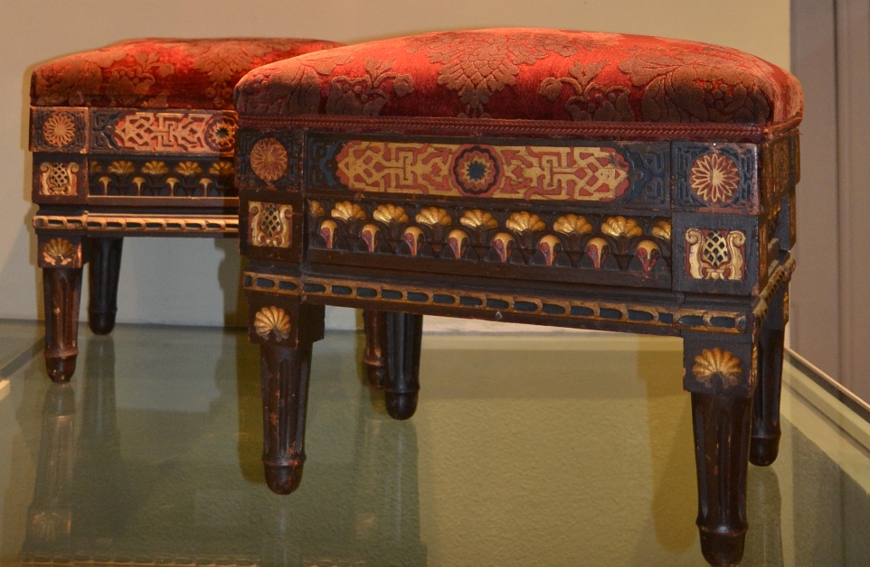 Pareja de banquetas antiguas con incrustaciones decorativas y tapizado rojo, pieza catalogada por ABM Arte en Madrid.